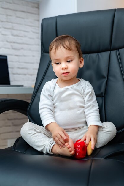 Szef Little wesoła baby siedzi na krześle Młody atrakcyjne dziecko na skórzanym krześle biurowym