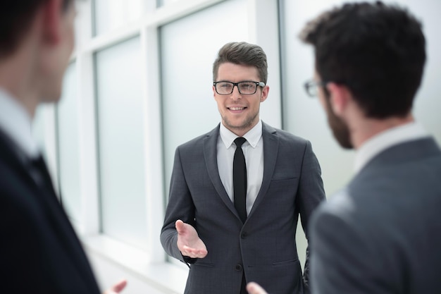 Szef rozmawia z pracownikami stojącymi w koncepcji officebusiness