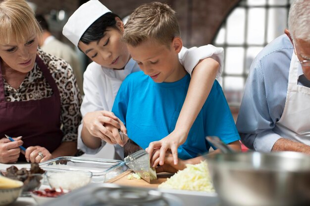 Zdjęcie szefowa kuchni uczy chłopca gotowania.