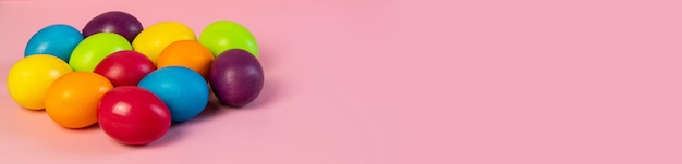 Szeroki baner wielkanocny pusty Wielobarwne jajka na różowym tle kopii przestrzeni tekstu makieta pocztówka