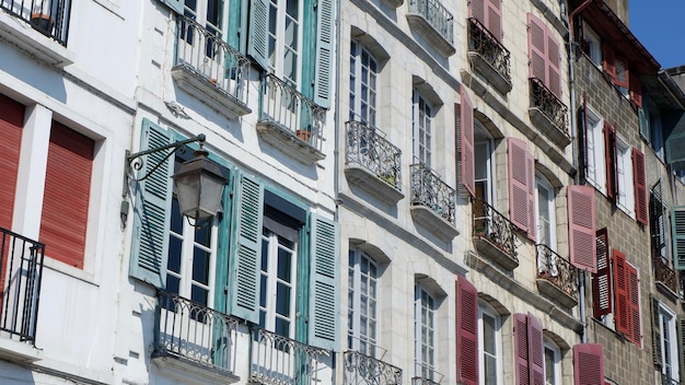 Szeroki kąt widzenia na kolorowe klasyczne fasady z okiennicami i malutkimi balkonami w centrum Bayonne Francuski kraj Basków Francja