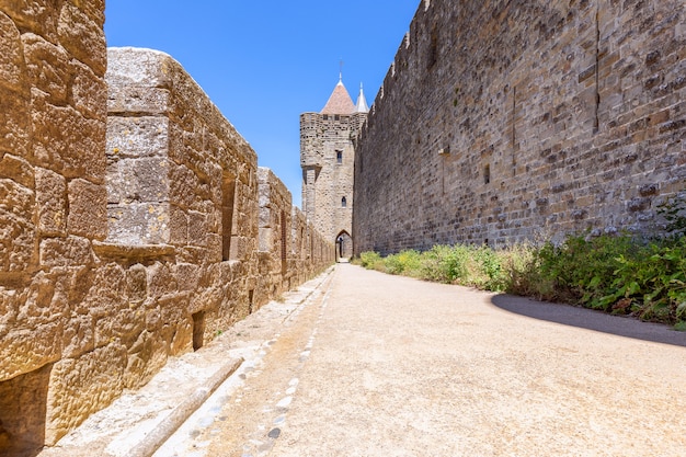 Szerokie mury obronne z chodnikami i łukami średniowiecznego zamku miasta Carcassonne