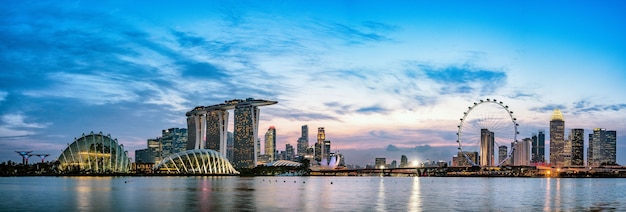 Szerokie zdjęcie panoramiczne przedstawiające panoramę Singapuru o zmierzchu