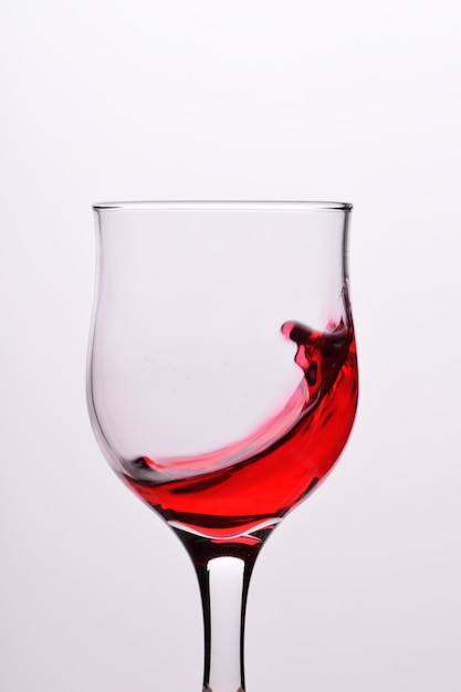 Szkła z fala plash czerwone wino na białym tle