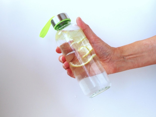 Szklana butelka sportowa w kobiecej dłoni