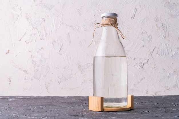 Zdjęcie szklana butelka z absolutnie czystą wodą destylowaną na powierzchniach grunge