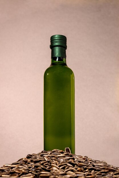 Szklana butelka z olejem słonecznikowym stoi w kupie nasion