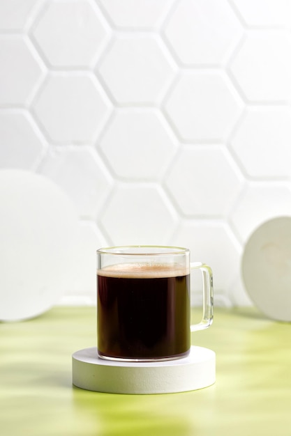 Szklana filiżanka kawy z espresso rano na podium i zielonym tle Aromat Kubek kawy