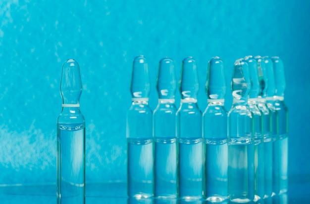 Szklana fiolka medyczna z ampułką do wstrzykiwań Lek jest płynnym chlorkiem sodu z wodnym roztworem w ampułce Zbliżenie Butelki ampułka wielokolorowa
