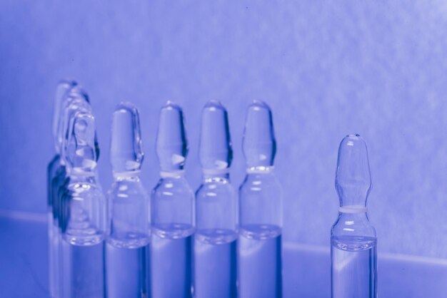 Szklana fiolka medyczna z ampułką do wstrzykiwań Lek jest płynnym chlorkiem sodu z wodnym roztworem w ampułce Zbliżenie Butelki ampułki wielokolorowe