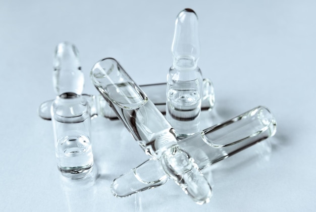 Zdjęcie szklane ampułki z lekiem do wstrzykiwań na jasnym tle