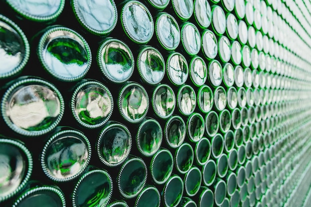 Szklane butelki zielone Zielone szklane butelki piwa Ściana utworzona przez zielone butelki Zielone tło butelek Pusta szklana butelka z oświetleniem