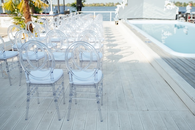 Szklane Krzesła Stoją W Rzędzie Podczas Pięknej Ceremonii ślubnej.