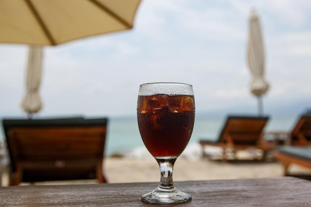 Szklanka coli na plaży z parasolami Napój chłodzący