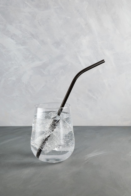 Zdjęcie szklanka czystej wody gazowanej z lodem i słomką
