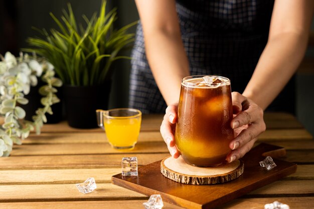 Szklanka espresso z sokiem pomarańczowym na drewnianym stole i miejsce na kopię Letni koktajl Zimny napar