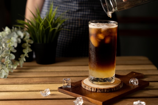 Szklanka espresso z sokiem z cytryny na drewnianym stole i miejsce na kopię Letni koktajl