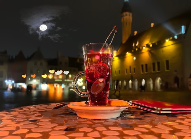 szklanka herbaty owocowej pn blat w ulicznej restauracji w średniowiecznym wieczornym mieście Stare miasto w Tallinie