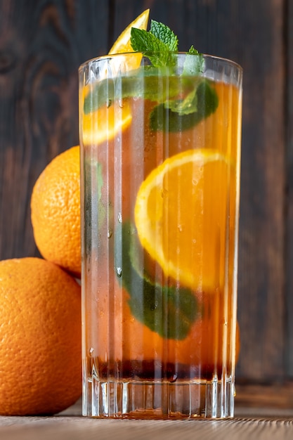 Szklanka holenderskiego koktajlu Orange Cup przyozdobiona plasterkiem pomarańczy i listkami świeżej mięty