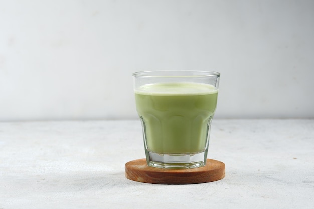 szklanka japońskiej zielonej herbaty matcha latte z mlekiem lub mlekiem sojowym z tłem