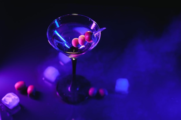 Szklanka klasycznego suchego koktajlu martini z oliwkami na ciemnym stole na czarnym tle z wolnym miejscem na tekst