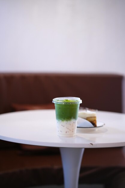 Zdjęcie szklanka lodu matcha zielona herbata latte na białym stole w kawiarni