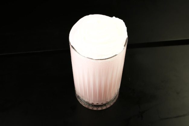 Szklanka malinowego koktajlu mlecznego z bitą śmietaną i świeżymi malinami