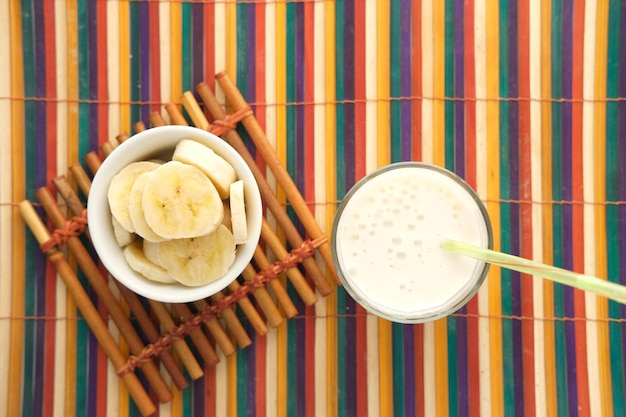 Zdjęcie szklanka mleka i banana na stole w godzinach porannych