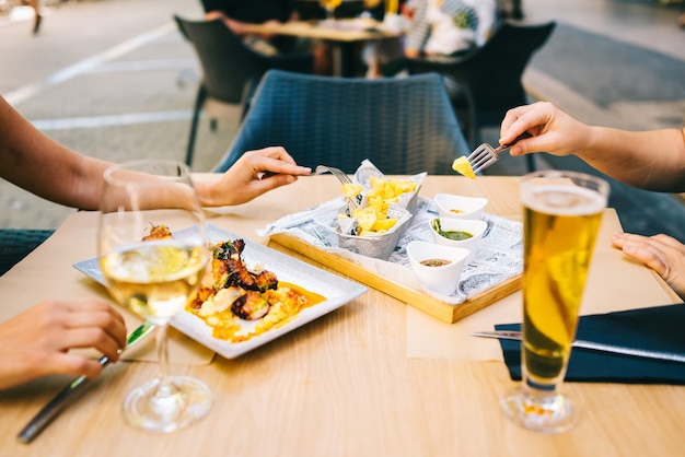 Zdjęcie szklanka piwa i wina na stole, jedzenie na tarasie - dwie dziewczyny jedzą razem obiad w restauracji