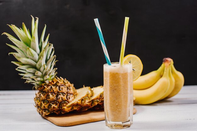 Szklanka smoothie z ananasem i bananami na tle. Koncepcja zdrowego życia