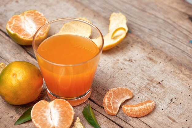 Szklanka soku mandarynkowego i świeżych obranych owoców