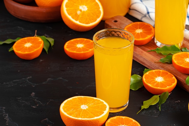 Szklanka soku pomarańczowego i pokrojone pomarańcze na stole