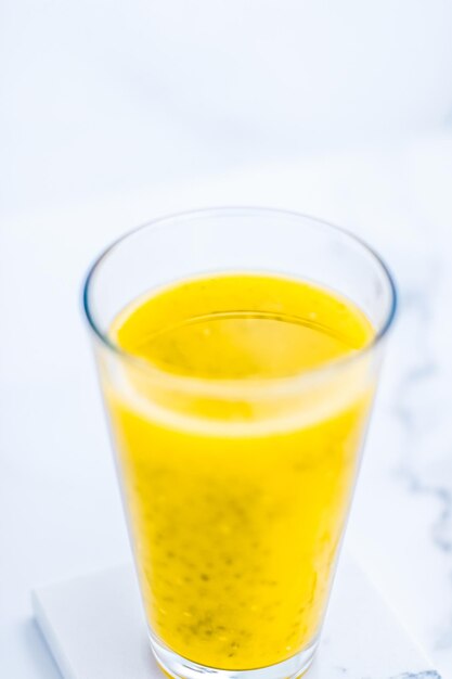 Szklanka soku z koktajlu owocowego z żółtymi owocami z nasionami chia do dietetycznego detoksykacji idealnego przepisu na śniadanie