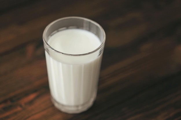 Szklanka świeżego mleka na drewniane tła