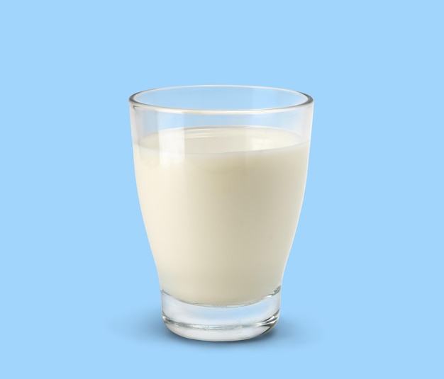 Szklanka świeżego mleka na jasnoniebieskim tle