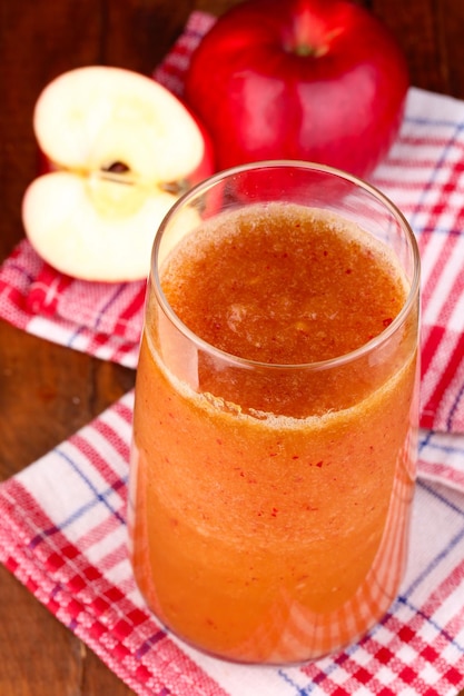 Szklanka świeżego soku jabłkowego na drewnianym stole