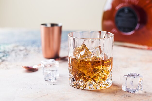 Szklanka Szkockiej Whisky Z Kostkami Lodu, Butelką I Akcesoriami W Postaci Miedzianego Baru