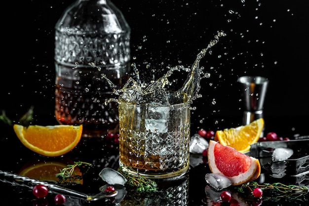 Szklanka whisky rozpryskuje się od spadającego lodu latającego w różnych kierunkach zamrożenie ruchu