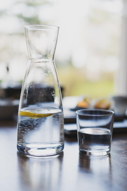 Szklanka wody i karafka na stole w kawiarni