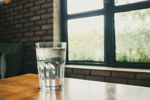 Szklanka wody mineralnej na stół z drewna w restauracji