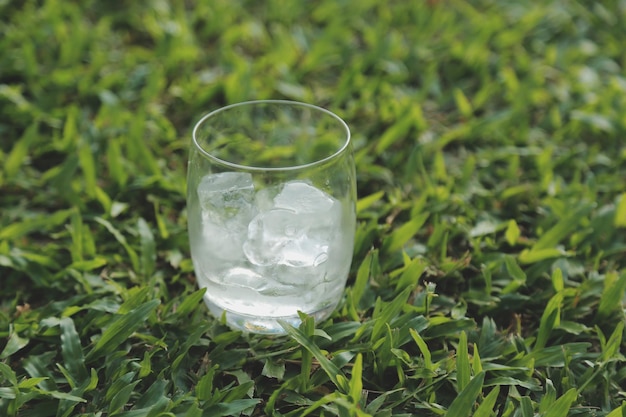 Szklanka wody z lodem na tle naturyxAxA