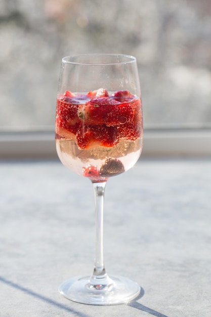 Szklanka z lodem Letni domowej roboty Zimny czerwony koktajl z sangrii z truskawkami w szkle na niebieskiej ścianie. Koncepcja wakacji, lato