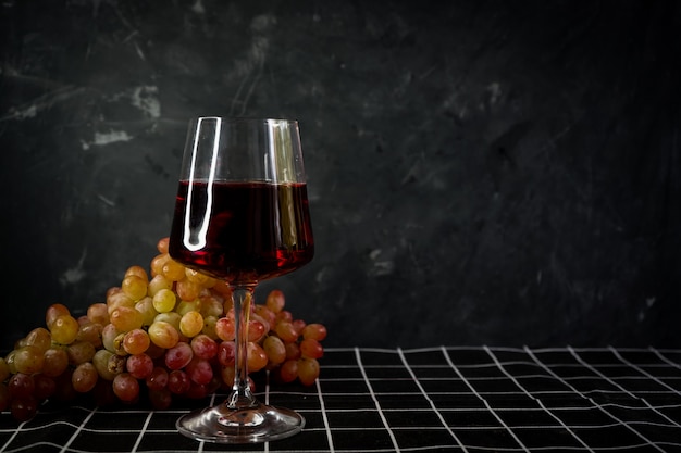szklanki czerwonego wina z bukietem różowych winogron
