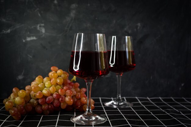 szklanki czerwonego wina z bukietem różowych winogron