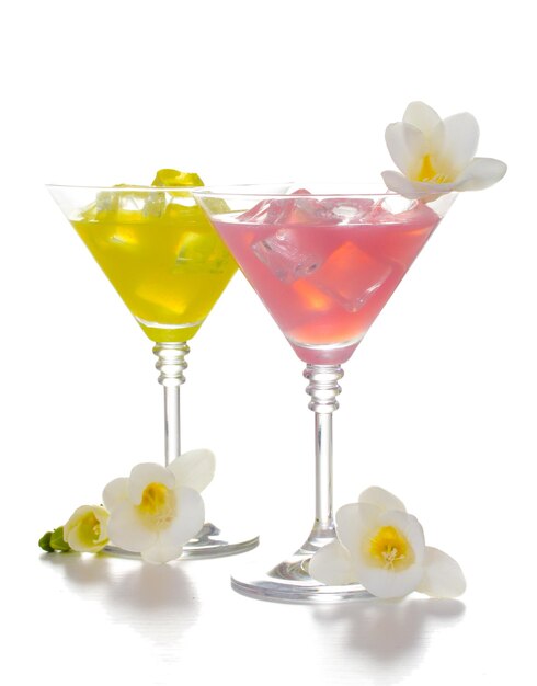 Zdjęcie szklanki martini z koktajlami z lodem i kwiatami izolowanymi na białym