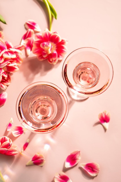 Szklanki różowego koktajlu z kwiatami i płatkami Przyjęcie urodzinowe lub koncepcja romantycznej pary walentynkowej Widok z góry