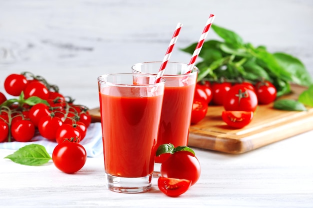 Szklanki soku pomidorowego z warzywami na drewnianym stole z bliska