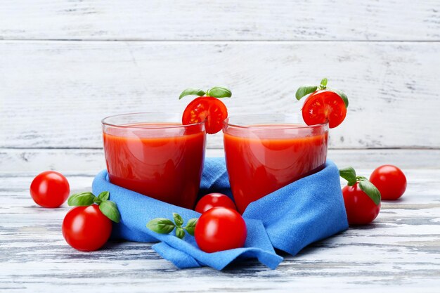 Szklanki soku pomidorowego z warzywami na podłoże drewniane