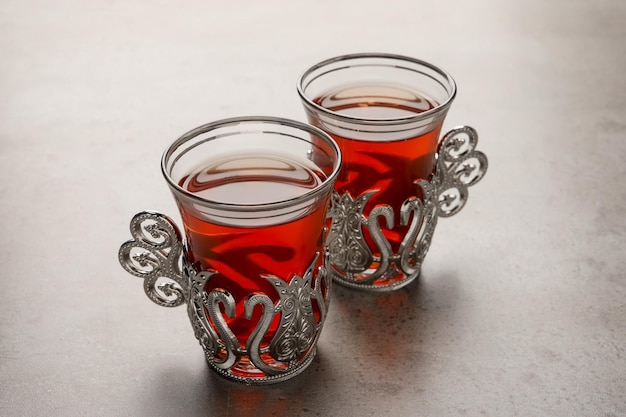 Szklanki tradycyjnej tureckiej herbaty w starych uchwytach na jasnoszarym stole