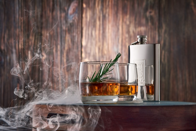 Szklanki whisky i kolby na drewnianym stole